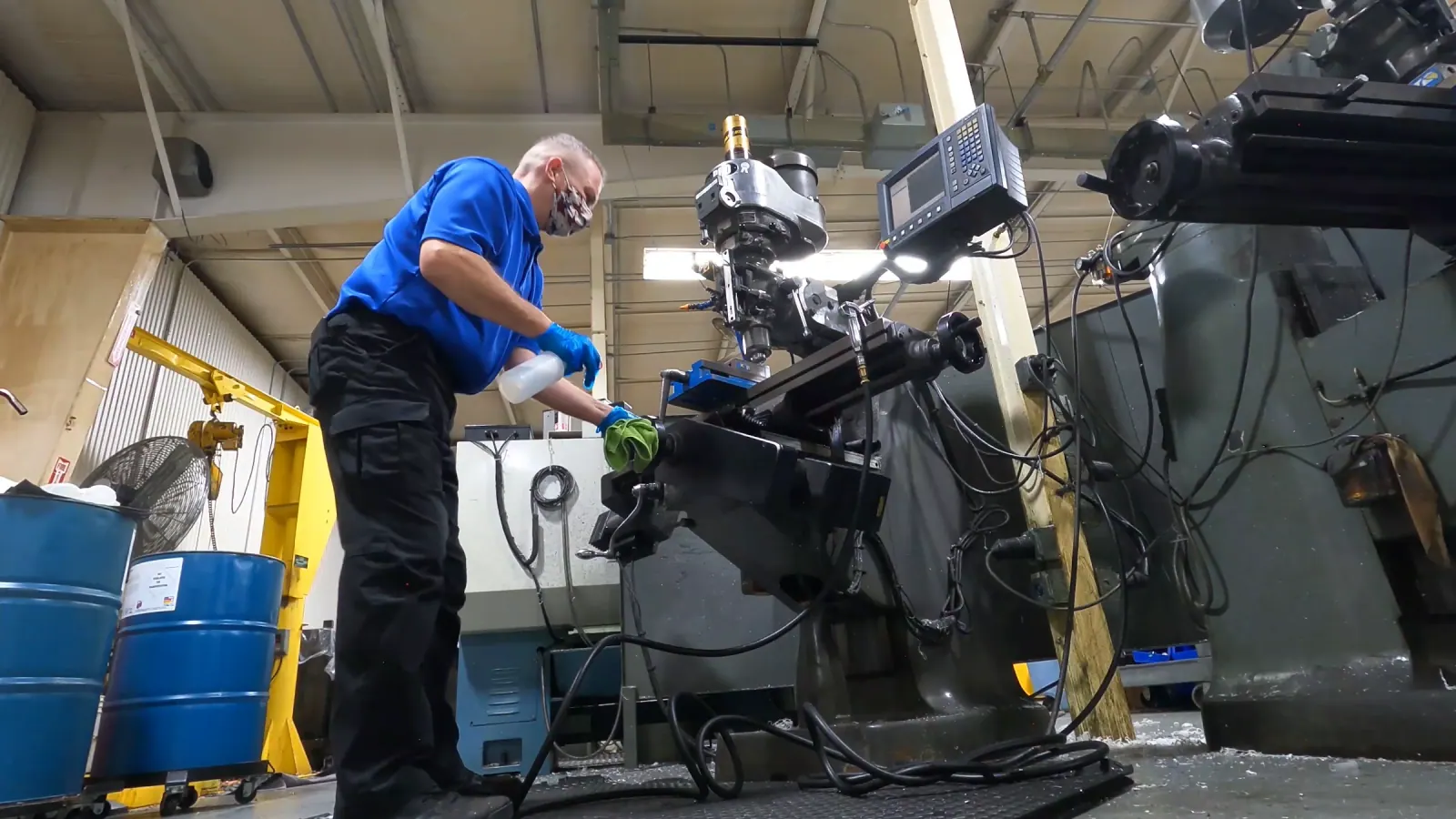 Technician degreasing machinery in a client's shop