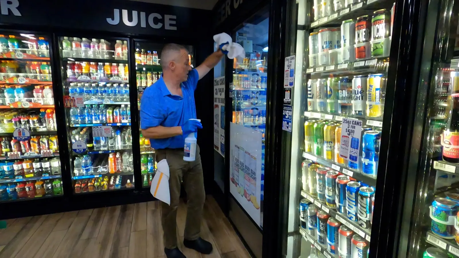 Technician cleaning and facing a retail beverage cooler